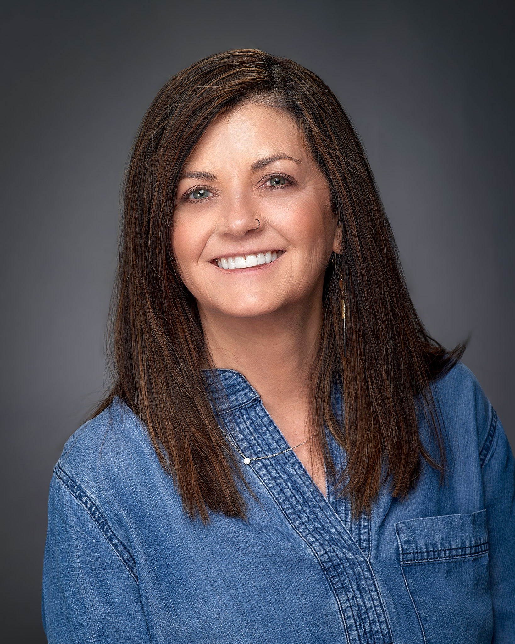 A smiling woman with dark hair and a blue shirt