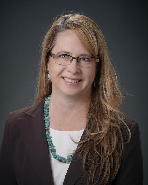 woman with blonde hair and glasses smiling